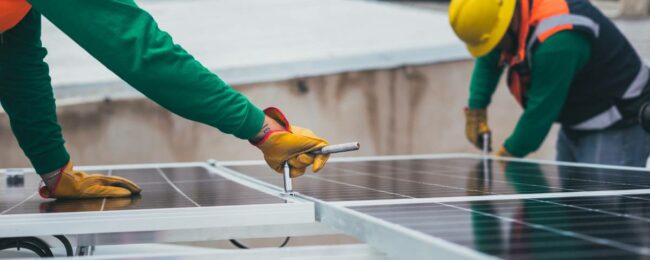 2 ouvriers qui réparent un panneau solaire